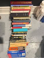 Entire row of stacked books showing variety of titles and spine conditions