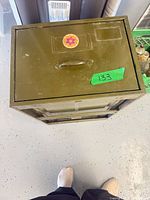 Top view of olive green metal file cabinet showing handle and surface wear