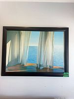 Seascape print in dark wood frame on wall