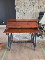 front view showing fold-out surface, drawers, turned stretcher, casters