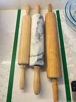 Top view of three rolling pins side by side on countertop
