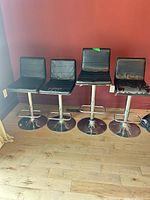 All four bar stools front view showing overall style and chrome bases