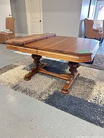 Rectangular solid wood dining table with pedestal base, medium brown finish