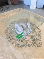 Overall view of square glass top resting on cast stone base