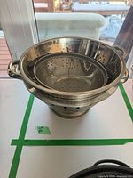 Stacked colander, steamer insert and mesh strainer showing overall lot
