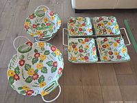 Two handled bowls and four square bowls in rack displaying floral pattern
