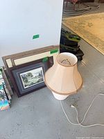 Lamp and stacked framed prints shown together