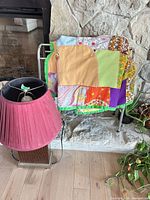 Quilt draped on rack with lamp beside, shows colors and relative sizes