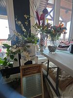 Group shot showing washboard, ceramic dispenser on stand, painted vase, clear vase with artificial flowers