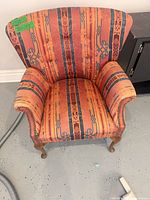 Front view of upholstered wingback armchair showing pattern, seat and legs