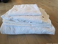 Stack showing quilted coverlet, shams, duvet cover and flat sheet