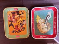 Both Coca-Cola trays side by side showing overall designs and size comparison