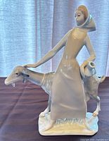 Full view of figurine showing woman, goat, jug and base