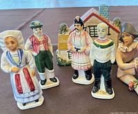 Group shot of four porcelain figures, ceramic cottage and partial ANRI figure