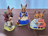 Three Royal Doulton Bunnykins figurines displayed upright