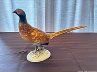 Full view of porcelain pheasant on oval base