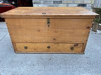 Front view showing chest, drawer, escutcheon