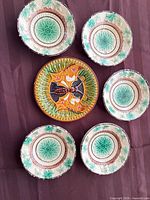 Grouped view of six matching leaf plates surrounding larger butterfly plate