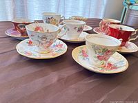 Group view of all seven teacup and saucer sets on table