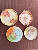All four decorative porcelain plates displayed together