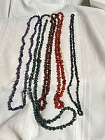 All five stone chip strands laid out side by side on white fabric