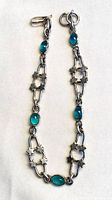 Full view of bracelet showing star links, teal cabochons and clasp