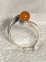 Bypass-style sterling silver ring with amber stone, side view