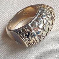 Wide band sterling silver ring showing raised dot motif and interior 925 stamp