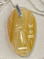Front view of agate mask pendant on sterling chain