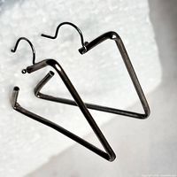 Pair of triangle silver earrings angled view