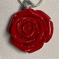 Close view of red acrylic rose pendant and sterling silver bale