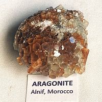 Front view of aragonite crystal cluster with identification label