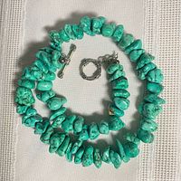 Full view of turquoise dyed howlite chip necklace coiled