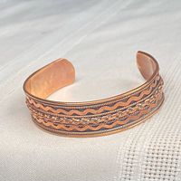Full view of copper cuff showing decorative exterior pattern