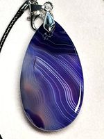 Close-up of purple banded agate teardrop pendant showing color and banding