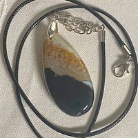 Front view of agate pendant on black cord