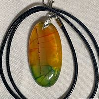 Front view of oval agate pendant on black cord