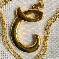 Close-up of gold-tone letter C pendant on chain