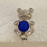 Closed teddy bear pendant showing blue pompom insert