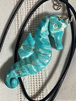 Front of carved howlite seahorse pendant on cord