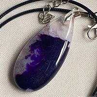 Front view of dyed purple agate teardrop pendant on black cord
