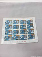 Full view of uncut stamp sheet in sleeve