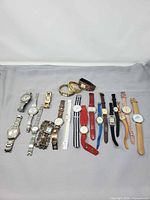 Group shot of all 21 wristwatches laid out on grey backdrop