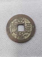 Obverse side showing Chinese inscription and square hole