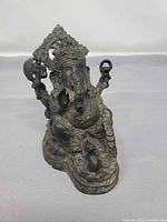 Front angled view of cast metal Ganesh figurine showing detailing and patina