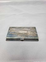 Closed front view showing cartouche and tarnish