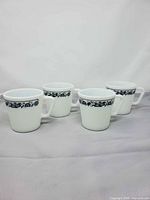 Four identical white mugs with blue band