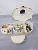 Overall view of open travel case, removable tray, zip pouch and jewellery contents