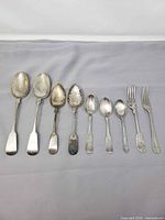 All eight flatware pieces laid out in size order