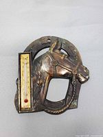 Front view showing horse head, horseshoe frame and thermometer